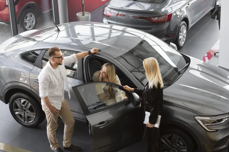 A couple inspects a car in a showroom, considering options and the relevance of Lemon Law for leased vehicles.