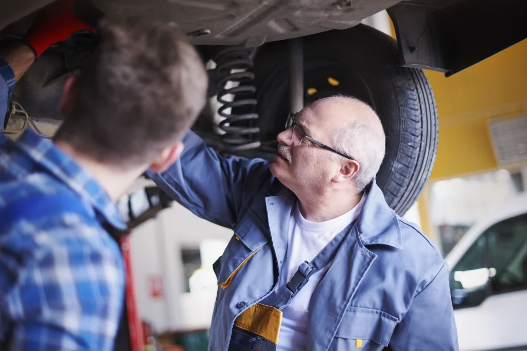 Mechanic inspecting Jeep brake and suspension problems during vehicle repair service