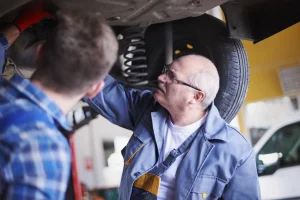 Mechanic inspecting Jeep brake and suspension problems during vehicle repair service