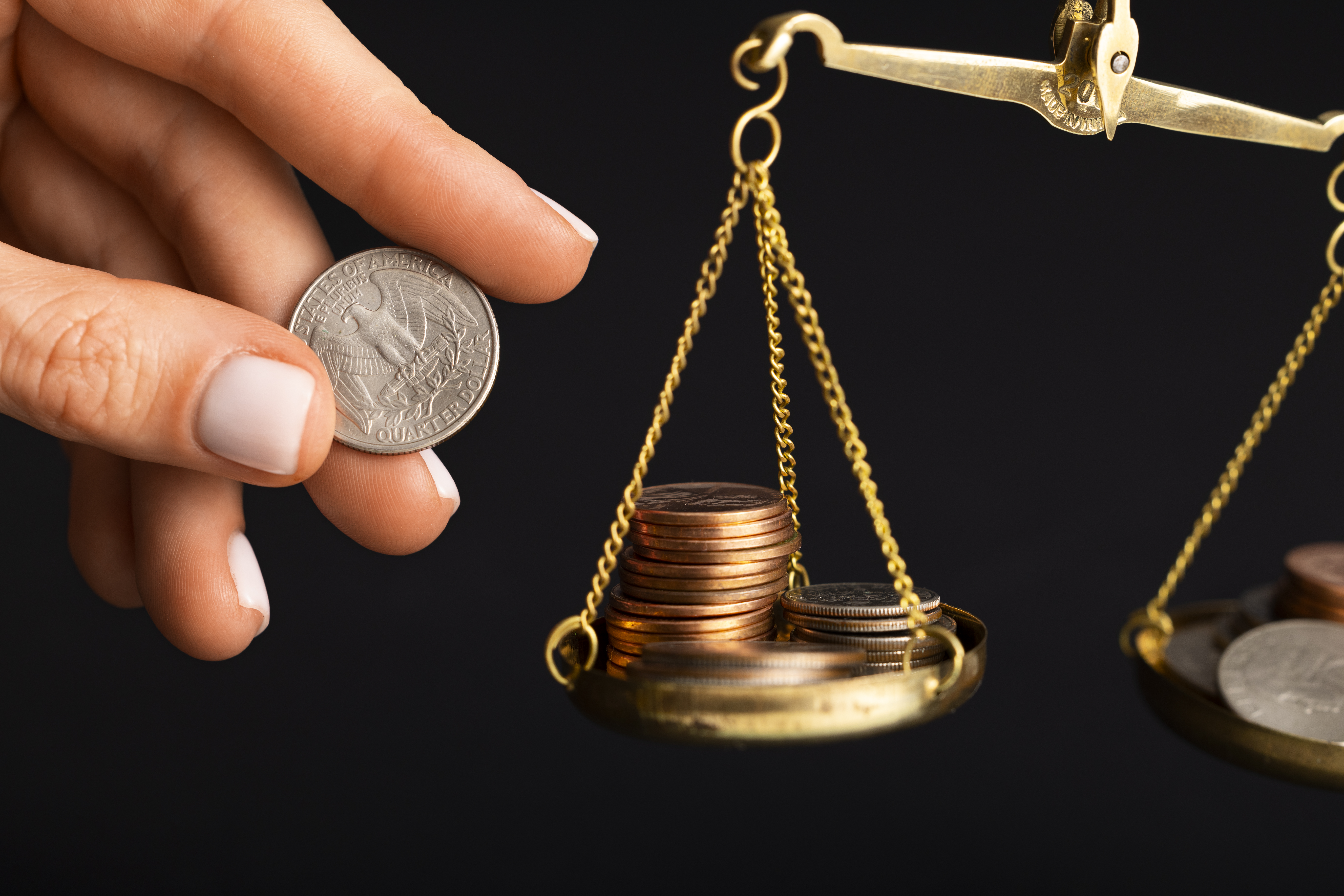 Scales balancing coins and currency, symbolizing the calculation and evaluation of lemon law settlement amounts and vehicle buyback compensation.