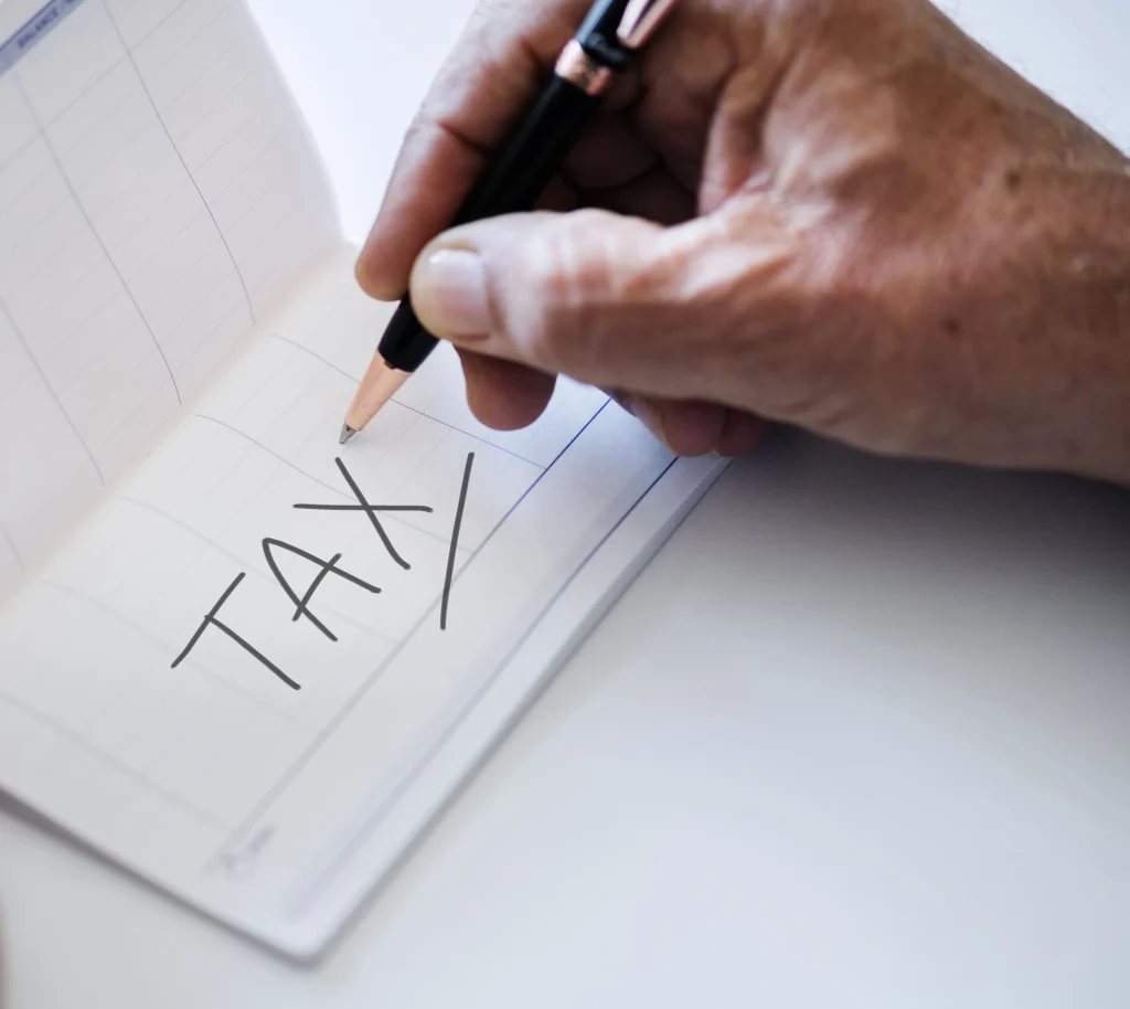 Notebook and pen displaying tax concepts, focusing on the taxability of Lemon Law settlements in California.